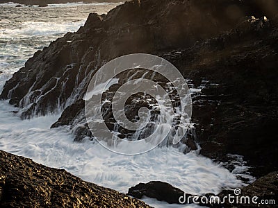 Long exposure of rough whitewater ocean sea wave flowing down cliff rock cascade natural power splash in Galicia Spain Stock Photo