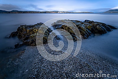 Long exposure shot of rocks in the sea in Moses Point, North Saanich, Vancouver Island, Canada Stock Photo