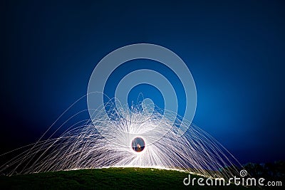 Long exposure shot of a spinning light beams in an evening blue sky Stock Photo