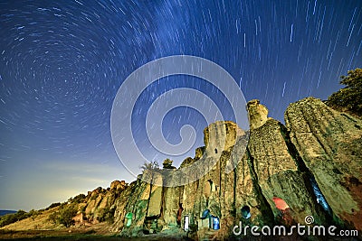 Star trails over rocky cliffside Stock Photo