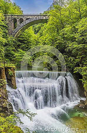 A long exposure view up the Radovna River towards falls and a railway bridge in the Vintgar Gorge in Slovenia Stock Photo