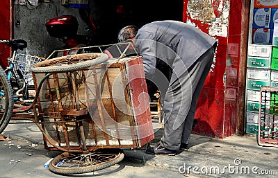Long Feng, China: Man Repairing Bicycle Cart Editorial Stock Photo