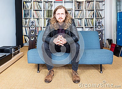 Long haired man intensively listening to music Stock Photo