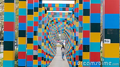Long hallway with colorful arches and a young woman in the distance Editorial Stock Photo