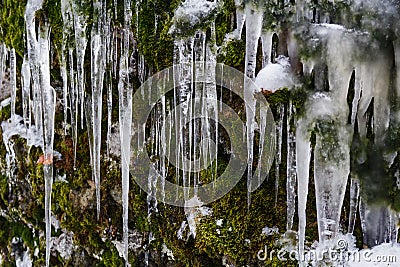 Long icicles hang down on the rocks Stock Photo