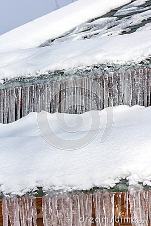 Long icicles on the roof. Icing at home. Stock Photo