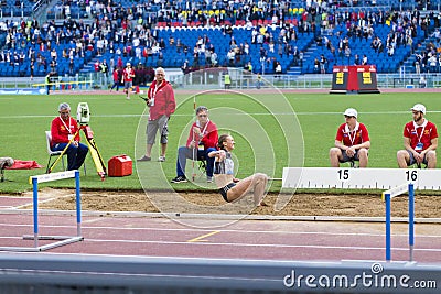 Long jump athlete landing in the sand pit Editorial Stock Photo