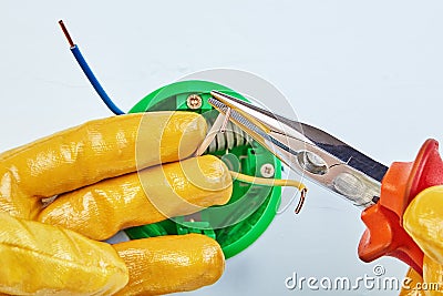 Long nose pliers installs round electrical box Stock Photo