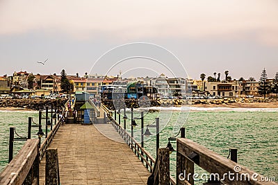 Long pier, walking people, residential houses on coastline of Sw Editorial Stock Photo