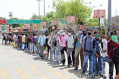 Long queue of Indian migrant laborers outside the railway station waiting to leave the city due to covid-19 pandemic. Editorial Stock Photo