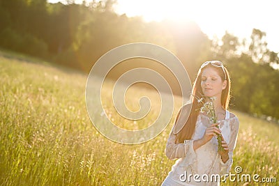 Long red hair woman in romantic sunset meadow Stock Photo