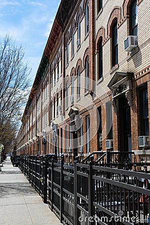 Row of Similar Apartment Buildings along an Empty Sidewalk in Astoria Queens New York Stock Photo