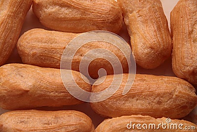 Long rows Eclair shells. Eclairs candy paper. The process of making cakes. Stock Photo