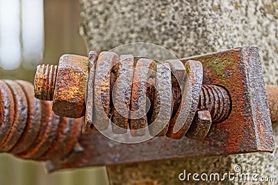 Long rusty brown bolt with many washers and a nut Stock Photo
