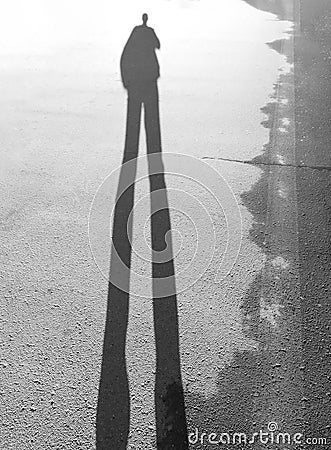 Long shadow of a man standing in the sunset Stock Photo