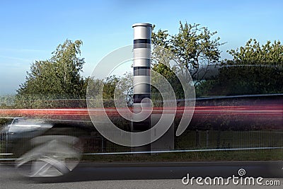 Long time exposure at a speed measuring device and a fast passing car in motion blur, automatic traffic monitoring with light Stock Photo