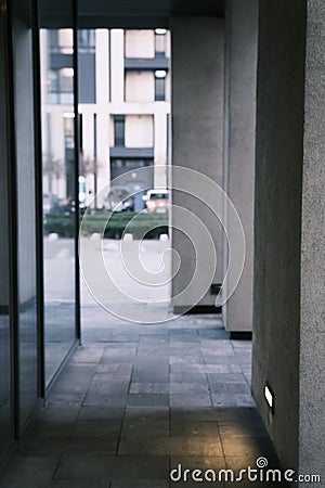 Long tunnel with columns and mirrors in modern city architecture with low lights and grey colors with tile on the frloor Stock Photo