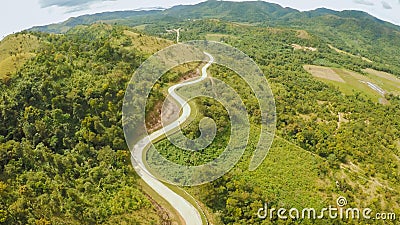 A long and winding road passing through green hills. Busuanga island. Coron. Aerial view. Philippines. Stock Photo