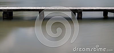 Long wooden boardwalk on a calm and placid mountain lake abstract view with copy space Stock Photo