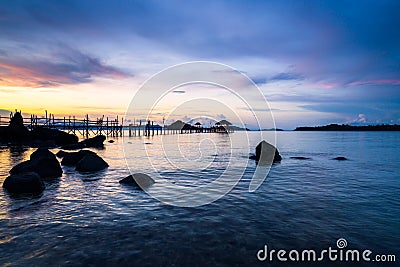 Long wooden bridge in tropical island beach at sunset Koh Mak Stock Photo