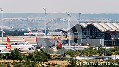Long zoom view of airplanes on tarmac and iconic roof of Bajaras Airport in Madrid, Spain Editorial Stock Photo