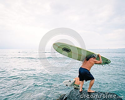 Longboard surfers entering the ocean Editorial Stock Photo