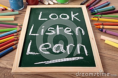 Look, Listen, Learn basic education concept, school desk, blackboard Stock Photo