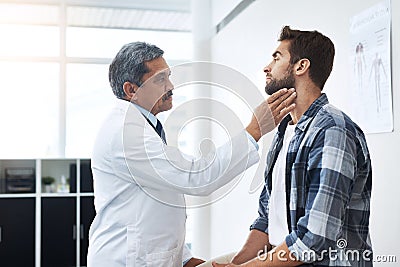 Look up for me. a mature male doctor doing a check up on a young patient whos seated on a doctors bed. Stock Photo