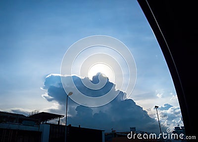 Looking through car window at Sun behind cloud on road in evening Stock Photo