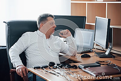 Looking at diagrams. Polygraph examiner works in the office with his lie detector`s equipment Stock Photo