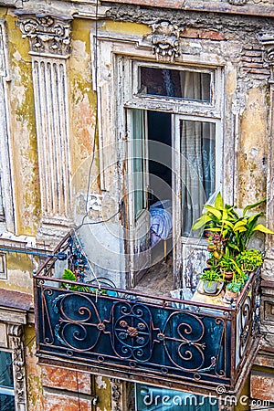 Looking down on a balcony in a grungy deteriorated but beautiful and ornate balcony in Eastern Europe with bed visiable through Stock Photo