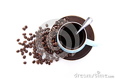 Looking down on a cup of coffee and scattered coffee beans on white background Stock Photo