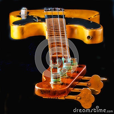 Looking Down the Neck of a Vintage Worn Electric Bass Guitar - View is strings, frets, body, knobs Stock Photo