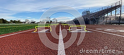 Looking down the track at yellow mini hurdles in two lanes Stock Photo