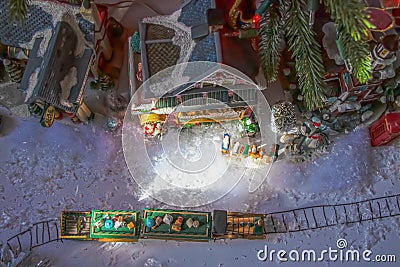 Looking down at under-the-tree Christmas village with train with presents on top and Santas Workshop and a gas station and Stock Photo