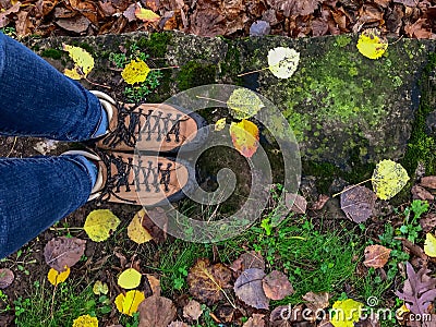 Looking down at woman`s feet in hiking boots on a rainy colorful Stock Photo