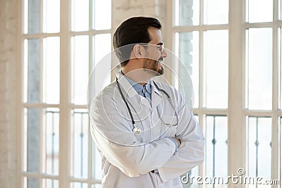 Successful young male doctor lead clinician dreaming of future perspectives Stock Photo