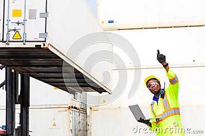 Looking forword. Foreman using laptop computer in the port of loading goods. Foreman showing thumbs up on Forklifts in the Stock Photo