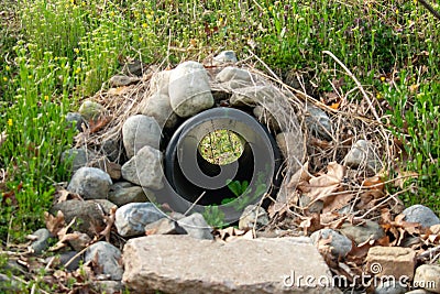 Looking Through a French Drain With a Black Pipe and Rocks Surrounded it Stock Photo