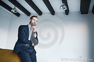 Looking just perfect. Young bearded businessman in a stylish dark suit is thinking about successful future Stock Photo