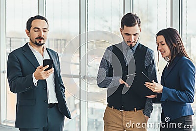 Three concentrated entrepreneurs working in office, trying to find a way to address some problems. Stock Photo