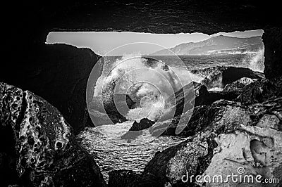 Looking through a space in the rocks to sea water crashing over rocks. La Pared, Fuerteventura Stock Photo