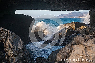 Looking through a space in the rocks to sea water crashing over rocks. La Pared, Fuerteventura Stock Photo