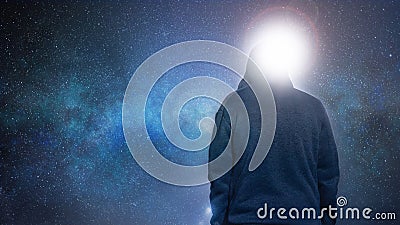 Looking up from behind at a mysterious, moody, hooded figure. With a universe and galaxy of stars in the background Stock Photo