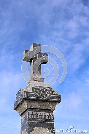 Looking up at an old stone grave monument with blue sky Stock Photo
