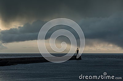 Looking up the River Tyne out to the North Sea at dawn, as large grey rain clouds loom over the Piers Stock Photo