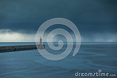 Looking up the River Tyne out to the North Sea at dawn, as large grey rain clouds loom over the Piers Stock Photo