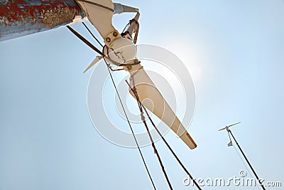 Looking up small broken wind turbine, strong midday sun shining on the sky Stock Photo