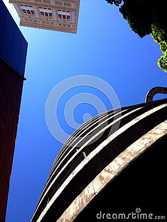 Looking Up at Spiral Parking Garage Ramp and Building and Tree Stock Photo