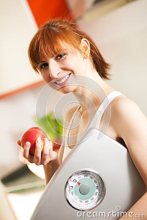 Loosing weight - woman with scale and apple Stock Photo